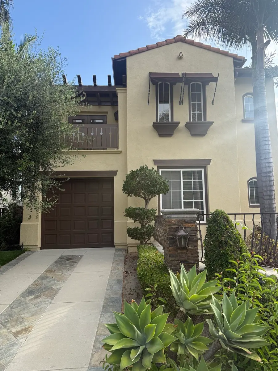 Mediterranean exterior in cream with dark timber garage