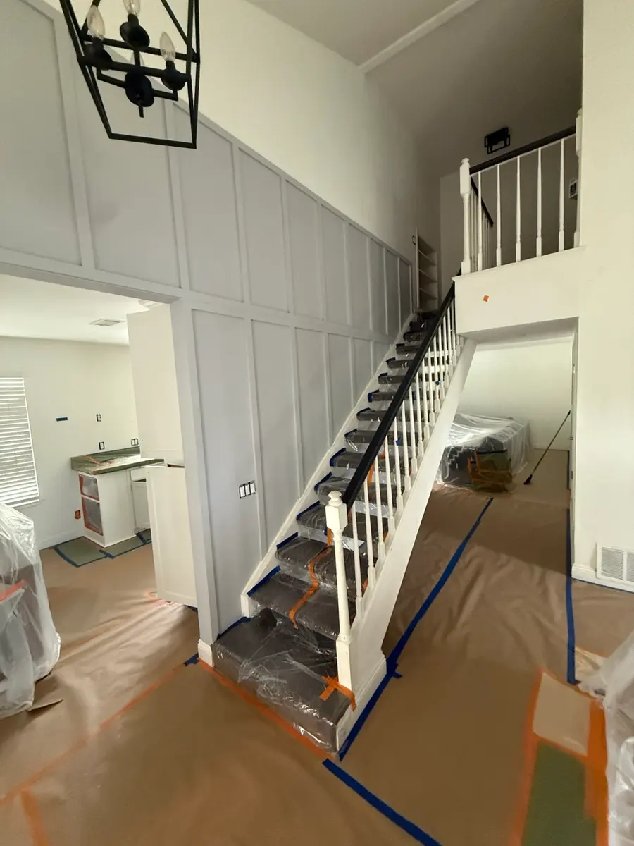 Stairwell with board and batten panelling, masked for painting