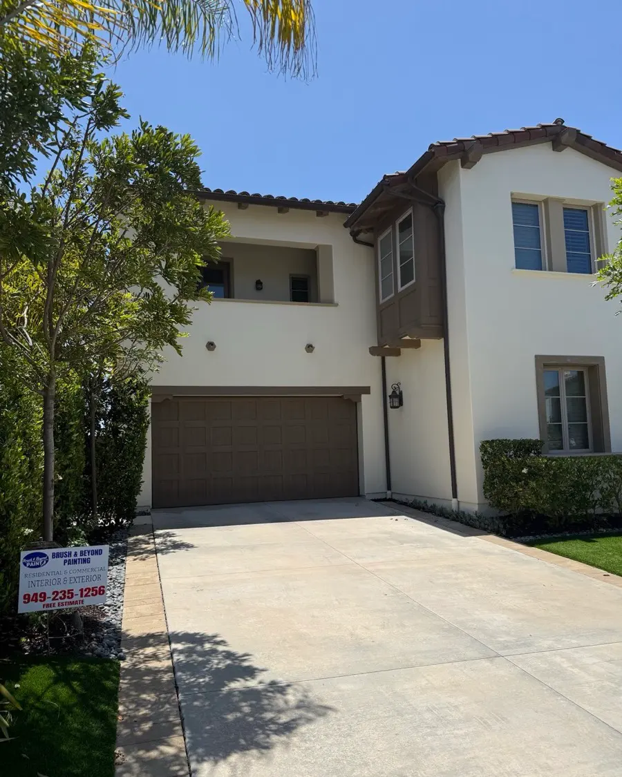 Exterior repaint on a home framed by palms