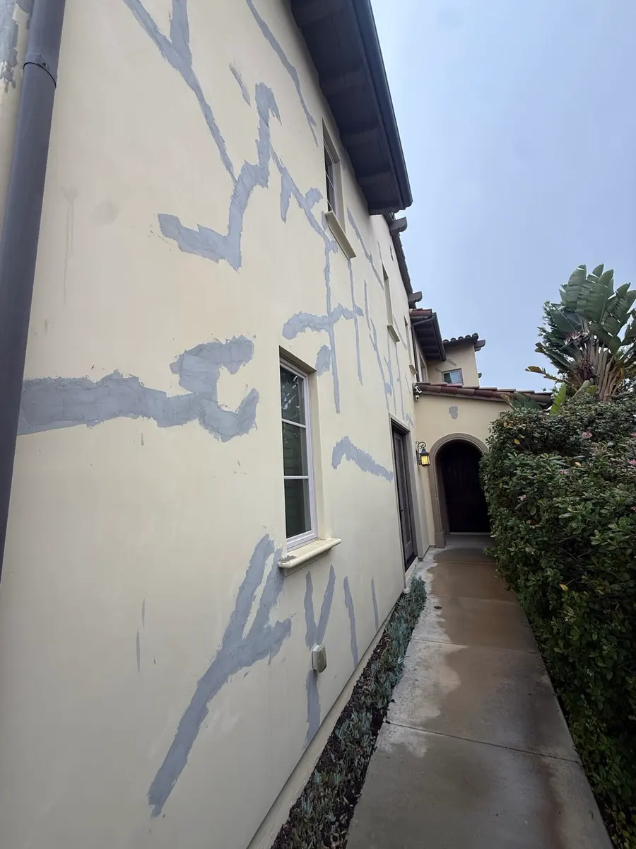 Stucco crack repair patched across an elevation before paint